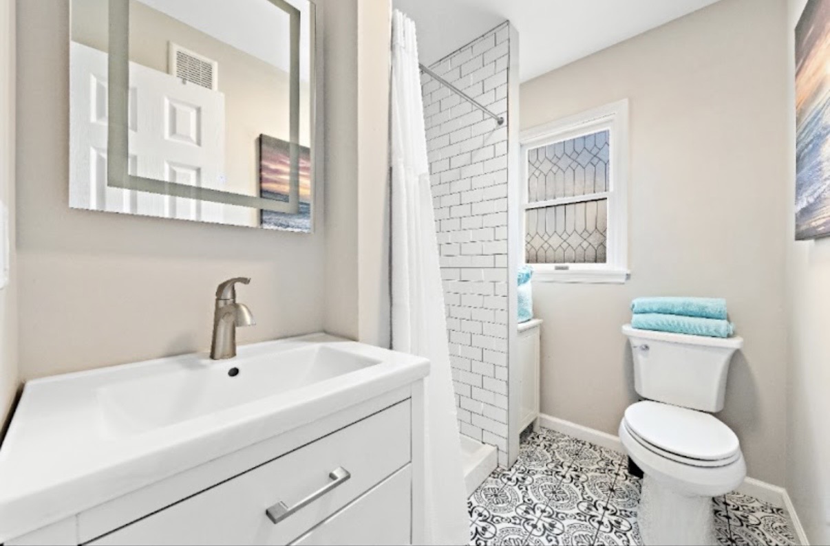 Guest bath with patterned floor tile and subway shower